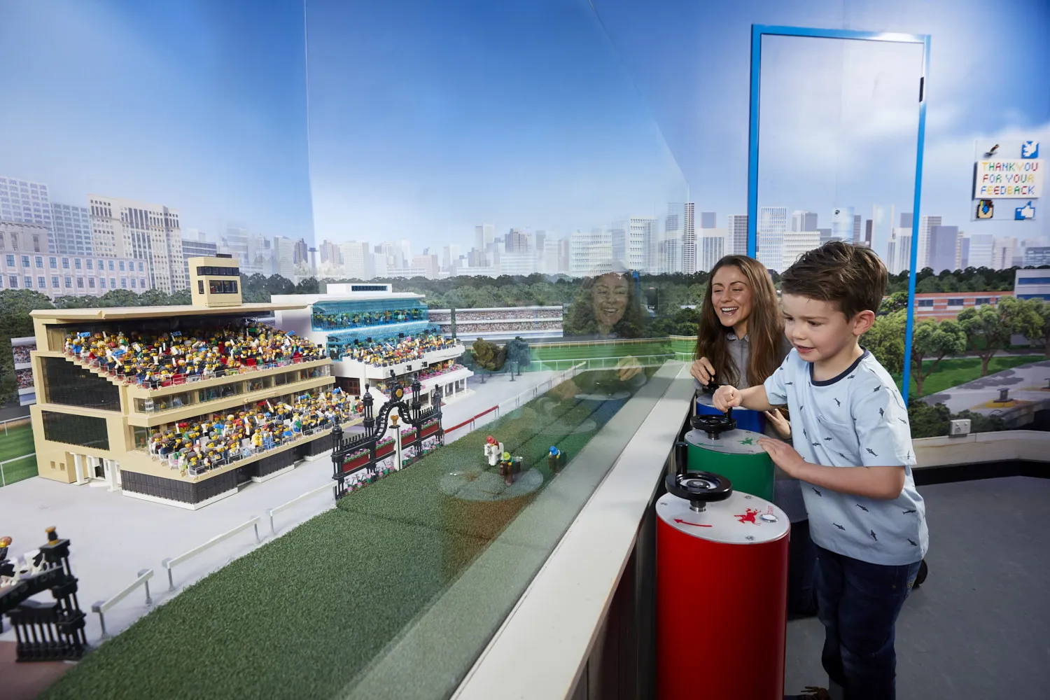 A mother and a son playing with lego at the horse races